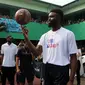 Pemain NBA dari Boston Celtics, Jaylen Brown menunjukkan kemampuannya memutar bola basket dengan satu jari saat memberi coaching clinics untuk siswa-siswi di SMAN 82 Jakarta, Kamis (26/7). (Liputan6.com/Arya Manggala)