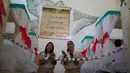 Narapidana perempuan dengan balutan kostum menyanyi selama acara tahunan menjelang  natal di Penjara Nelson Hungria, Rio de Janeiro, Kamis (13/12). Penjara ini mengadakan kompetisi menghias sel menggunakan dekorasi bernuansa natal. (AP/Silvia Izquierdo)