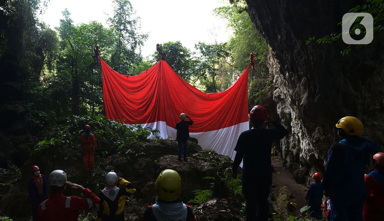 Pegiat panjat tebing membentangkan Bendera Merah Putih memperingati HUT ke-75 RI di Tebing Kutalingkung, Jawa Barat, Senin (17/8/2020). Pengibaran bendera untuk menyelamatkan tebing Kutalingkung yang memiliki potensi destinasi wisata  dari aktivitas pertambangan. (merdeka.com/Imam Buhori)