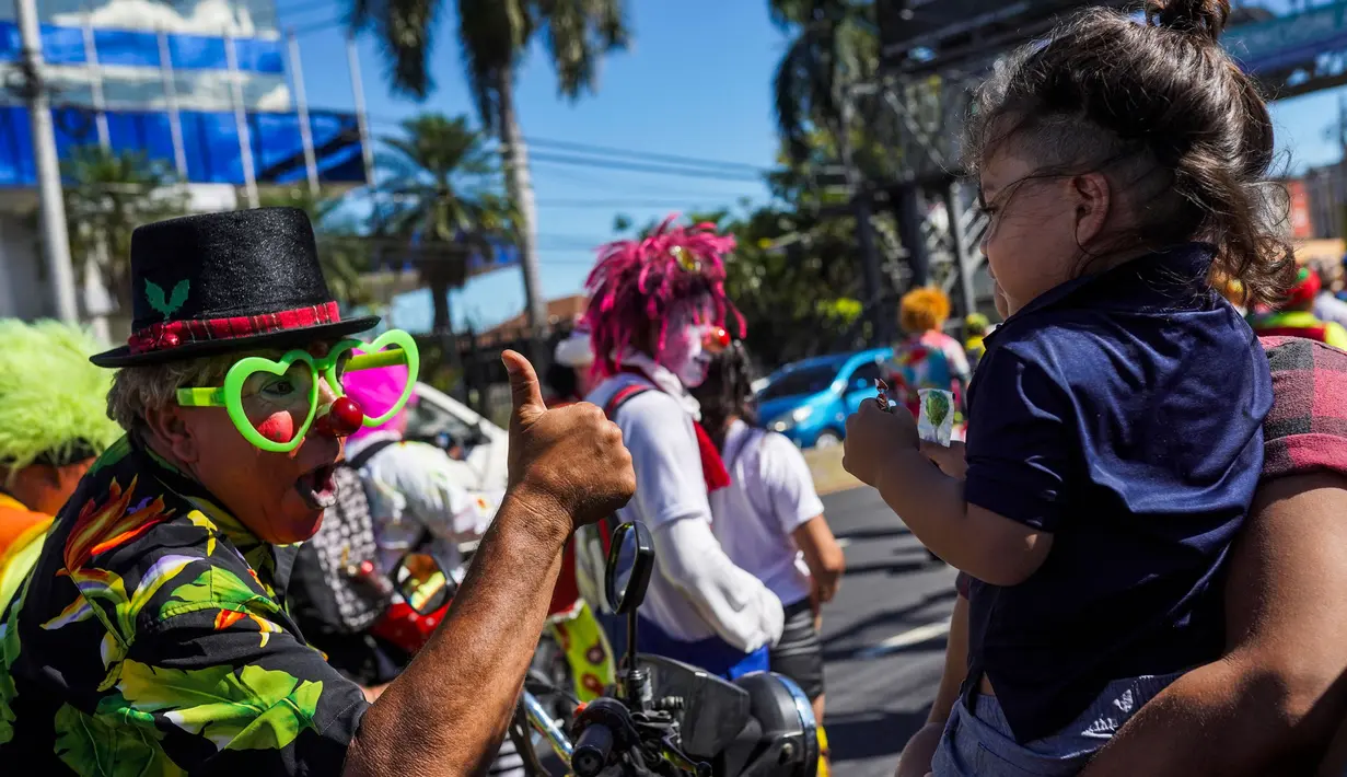 Para badut juga berinteraksi dengan seorang anak. (Camilo FREEDMAN/AFP)
