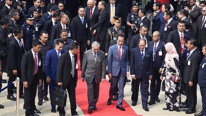 Presiden Joko Widodo disambut Menteri Malaysia Mahathir Mohamad saat melakukan pertemuan di Putrajaya (8/8/2019). Pertemuan ini merupakan kunjungan balasan yang dilakukan PM Mahathir tahun lalu. (Farhan Abdullah/Department Of Information/AFP)
