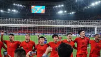 Sejumlah pemain China bernyanyi dengan para pendukung mereka setelah laga lanjutan putaran ketiga Grup C Kualifikasi Piala Dunia 2026 melawan Timnas Indonesia di Qingdao Youth Stadium, Qingdao, China, Selasa (15/10/2024). (AFP)