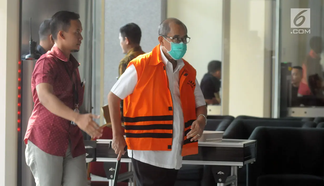 Bupati Bandung Barat Abubakar mengenakan masker dan membawa tongkat berjalan menuju ruang pemeriksaan di gedung KPK, Jakarta, Selasa (8/5). (Merdeka.com/Dwi Narwoko)