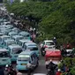 Puluhan mikrolet M 44 jurusan Kampung Melayu-Karet berderet menutupi persimpangan jalan layang KH Abdulah Syafei, Jakarta, Rabu (25/5). Menurut pengemudi, aksi ini bentuk protes tindakan penderekan mobil rekan mereka. (Liputan6.com/Helmi Fithriansyah)