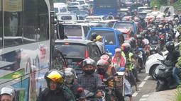 Pengendara berjalan tersendat akibat padatnya volume kendaraan menuju jalur Puncak, Gadog, Bogor, Jawa Barat, Minggu (15/5/2022). Kemacetan panjang kendaraan terjadi di kawasan wisata Puncak memasuki libur panjang Hari Raya Waisak. (merdeka.com/Arie Basuki)