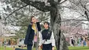 Ayu Ting Ting mengajak putrinya, Bilqis dan orangtuanya ke Jepang. Berfoto di bawah pohon sakura, Ayu Ting Ting mengenakan atasan jaket hitam senada dengan celana flarenya. Dipadukan syal warna kuning. [@ayutingting92]