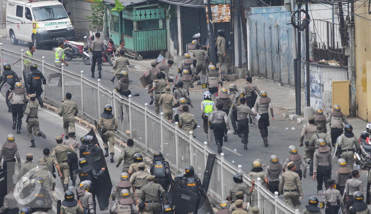 Petugas kepolisian dan Satpol PP saat menertibkan lokasi penggusuran Kampung Pulo, Jakarta, Kamis (20/8/2015). Penggusuran pemukiman Kampung Pulo dilakukan oleh 2.200 personel gabungan untuk normalisasi Sungai Ciliwung. (Liputan6.com/Herman Zakharia)