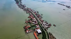 Foto yang diambil pada 30 Juli 2025 menunjukkan pemandangan udara rumah-rumah yang sebagian terendam akibat kehilangan lahan akibat perubahan iklim di Desa Bedono, Demak, Jawa Tengah. (BAY ISMOYO/AFP)