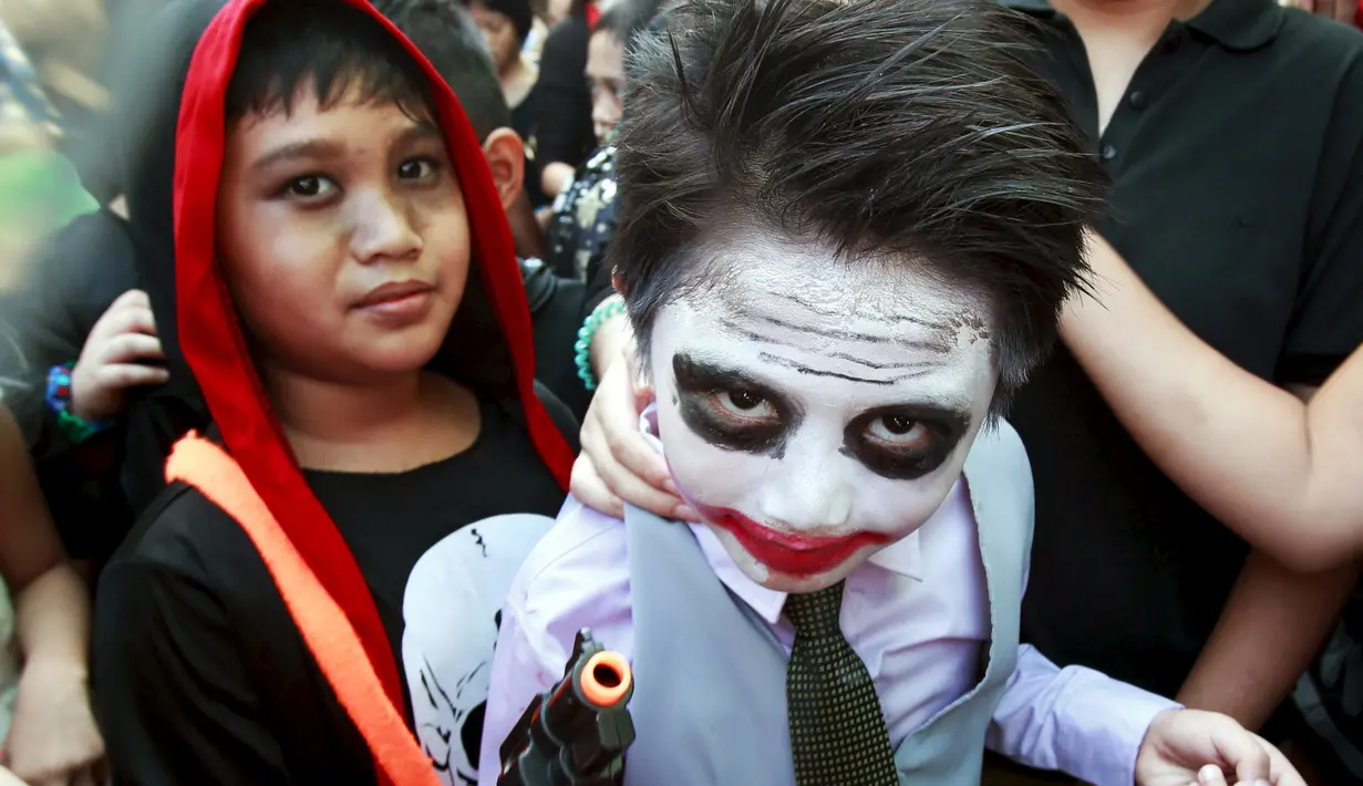 Siswa sekolah Brainshire Sains memakai kostum  Joker dalam film Batman selama parade halloween di kota Paranaque, Filipina, Jumat (30/10/2015). Anak - anak ini ikut merayakan halloween yang dirayakan setiap akhir bulan oktober. (REUTERS/Romeo Ranoco)