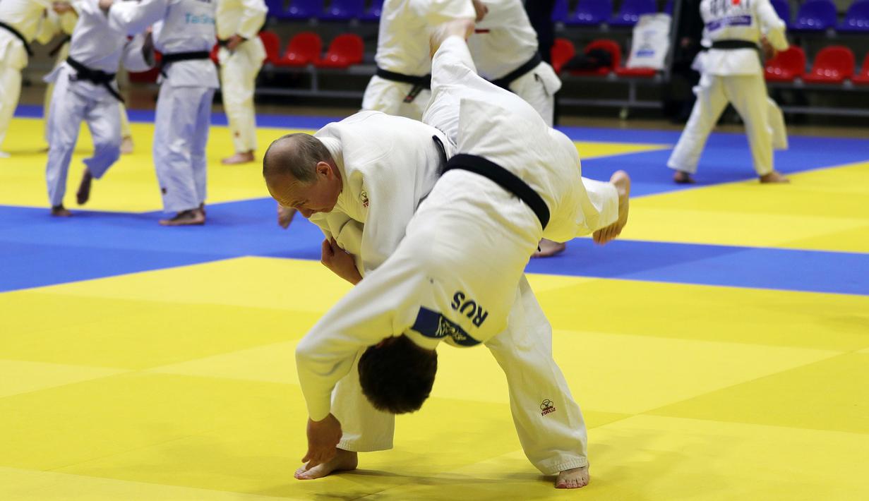 Presiden Rusia, Vladimir Putin mengambil bagian dalam sesi latihan judo bersama atlet nasional Rusia di Sochi, Kamis (14/2). Judo merupakan salah satu olahraga kegemaran Putin yang telah digeluti sejak masa muda. (Mikhail KLIMENTYEV/SPUTNIK/AFP)