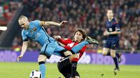 Gelandang Barcelona, Andres Iniesta (kiri) berduel kontra pemain Athletic Bilbao, Ander Iturraspe, pada laga pertama babak perempatfinal Copa del Rey, di Stadion San Mames, Rabu (20/1/2016). Iniesta bakal mencatat rekor jika bermain bersama Lionel Messi, 