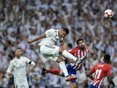 Gelandang Real Madrid, Casemiro, duel udara dengan striker Atletico Madrid, Diego Costa, pada laga La liga di Stadion Santiago Bernabeu, Madrid, Sabtu (29/9/2018). Kedua klub bermain imbang 0-0. (AFP/Oscar Del Pozo)