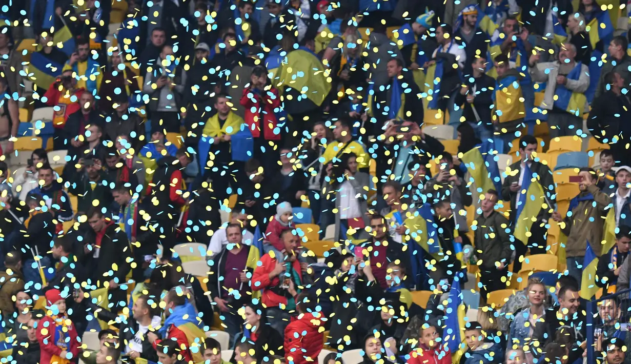 Suporter merayakan kemenangan Ukraina atas Portugal pada laga Kualifikasi Piala Eropa 2020 di Stadion NSK Olimpiyskyi, Kiev, Senin (14/10). Ukraina menang 2-1 atas Portugal. (AFP/Genya Savilov)