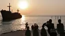 Sejumlah turis melihat matahari tenggelam atau sunset di pinggir laut, Pulau Kish, Iran, 1 November 2016. Iran sedang menjadi perbincangan di dunia wisata berkat upaya dari pemerintahan yang kembali menjalin hubungan dengan Barat. (Atta Kenare/AFP)