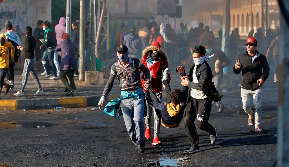 Demonstran antipemerintah yang terluka dibawa untuk menerima pertolongan pertama saat bentrok dengan pasukan keamanan di Najaf, Irak, Kamis (28/11/2019). Kerusuhan di Ibu Kota dan wilayah selatan Irak terus meningkat setelah pembakaran gedung Konsulat Iran. (AP Photo/Anmar Khalil)
