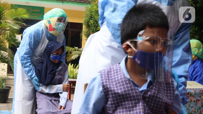 Siswa Sekolah Dasar (SD) bersiap untuk imunisasi di SDN Tangerang 1, Kota Tangerang, Kamis (19/11/2020). Pemberian imunisasi tersebut untuk memberikan perlindungan kepada anak-anak usia SD serta meningkat daya tahan tubuh serta mencegah berbagai penyakit. (Liputan6.com/Angga Yuniar)
