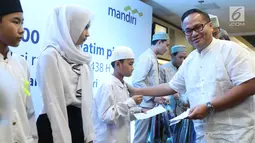 Direktur Utama Bank Mandiri Kartika Wirjoatmodjo tengah memberikan bingkisan Ramadan kepada sejumlah anak yatim di Jakarta, Minggu (11/6). Santunan ini sebagai bentuk empati dan wahana berbagi kebahagiaan di bulan Ramadan. (Liputan6.com/Angga Yuniar)
