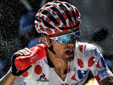 Pemegang kaus polkadot asal Polandia, Rafal Majka, menyemprotkan air ke wajahnya saat beraksi dalam Etape 17 Tour de France berjarak 184,5 km antara Berne dan Finhaut-Emosson, Prancis (20/7/2016). (AFP/Jeff Pachoud)