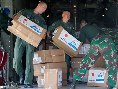 Personil militer Jepang dibantu TNI mengangkut bantuan logistik untuk korban gempa dan tsunami dari sebuah pesawat kargo Angkatan Udara Jepang di bandara Mutiara Sis Al-Jufri di Palu, Sulawesi Tengah, Indonesia (6/10). (AP Photo/Tatan Syuflana)