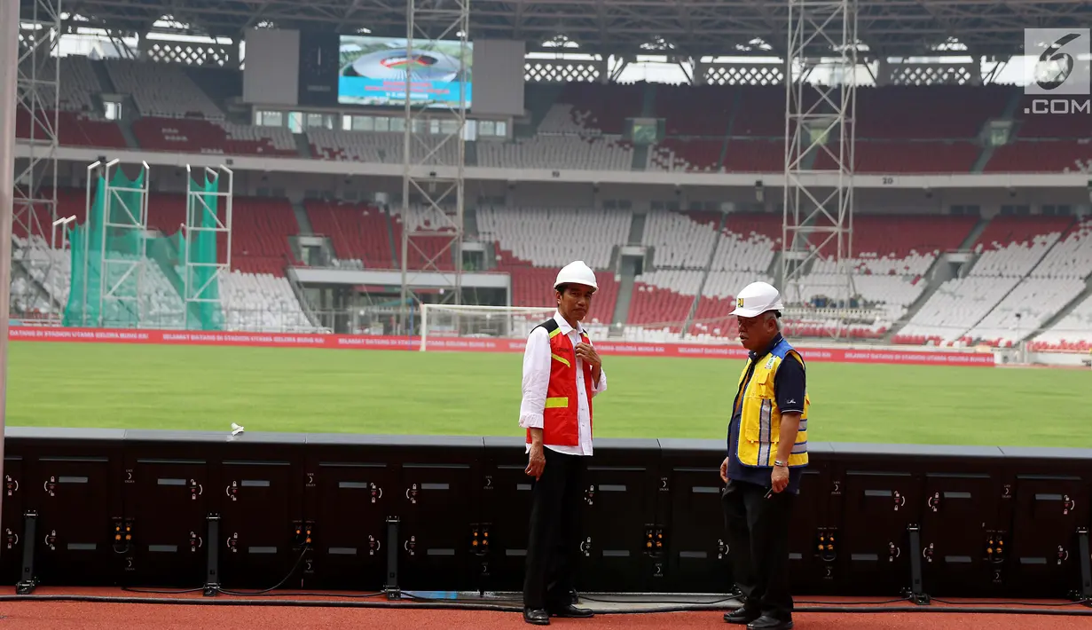Presiden Joko Widodo (Jokowi) berbincang dengan Menteri Pekerjaan Umum dan Perumahan Rakyat Basuki Hadimuljono ketika meninjau renovasi Stadion Utama Gelora Bung Karno, Jakarta, Kamis (19/10). (Liputan6.com/Angga Yuniar)