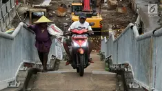 Pengendara motor melintas di samping pejalan kaki menaiki Jembatan Penyeberangan Orang kawasan Cikunir, Bekasi Barat, Senin (12/3). JPO yang diperuntukkan bagi pejalan kaki ini justru digunakan pemotor mencari jalan pintas. (Liputan6.com/Arya Manggala)
