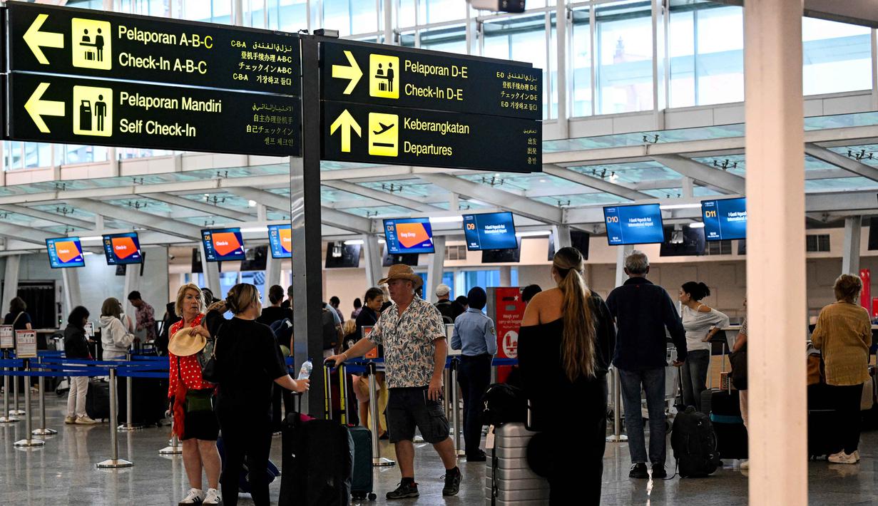 Para penumpang menunggu di tengah gangguan penerbangan akibat serangan Israel-Amerika Serikat terhadap Iran, di Bandara Internasional I Gusti Ngurah Rai, Bali, pada Senin 2 Maret 2026. Penutupan ruang udara di sejumlah negara kawasan Timur Tengah berimbas pada pembatalan sejumlah penerbangan oleh maskapai di dua Bandar Udara (Bandara) Internasional di Indonesia. (SONNY TUMBELAKA/AFP)