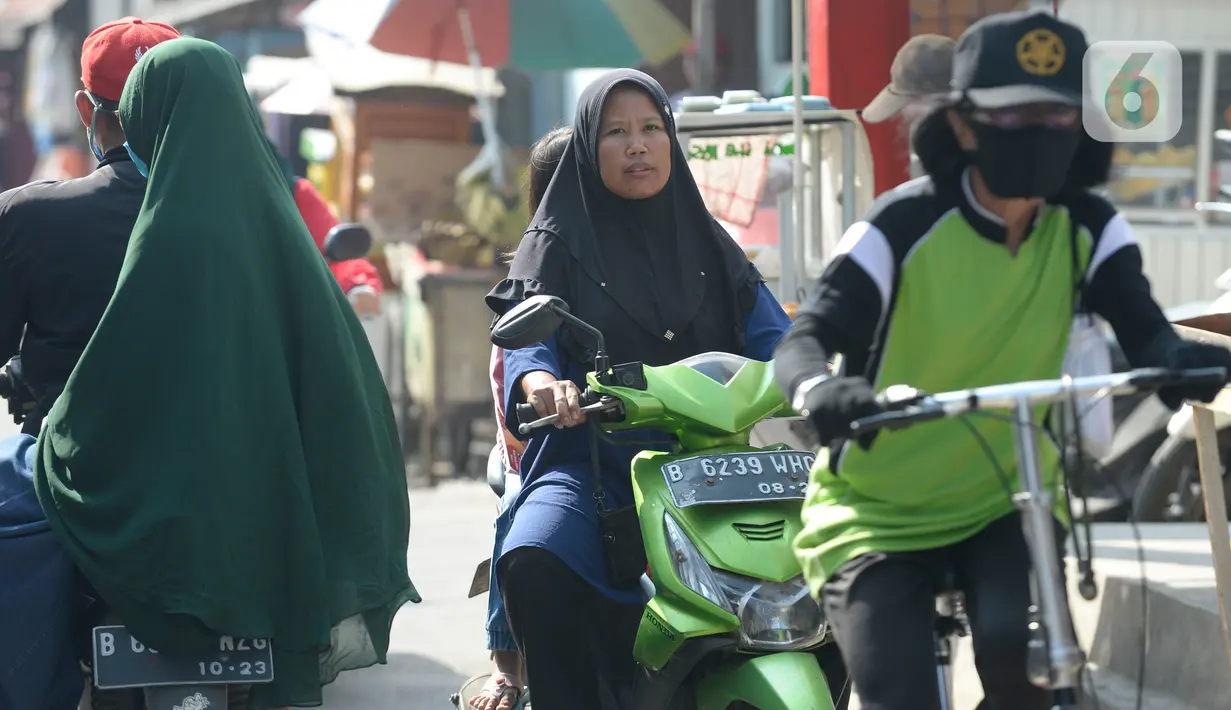 Pengendara motor tidak mengenakan masker masuk ke Pasar Bukit di Tangerang Selatan, Banten, Rabu (22/7/2020). Warga masih tidak peduli kesehatan dirinya sendiri dan orang lain, tentang bahayanya penyeberan virus corona (COVID-19) yang terus meningkat di Indonesia. (merdeka.com/Dwi Narwoko)