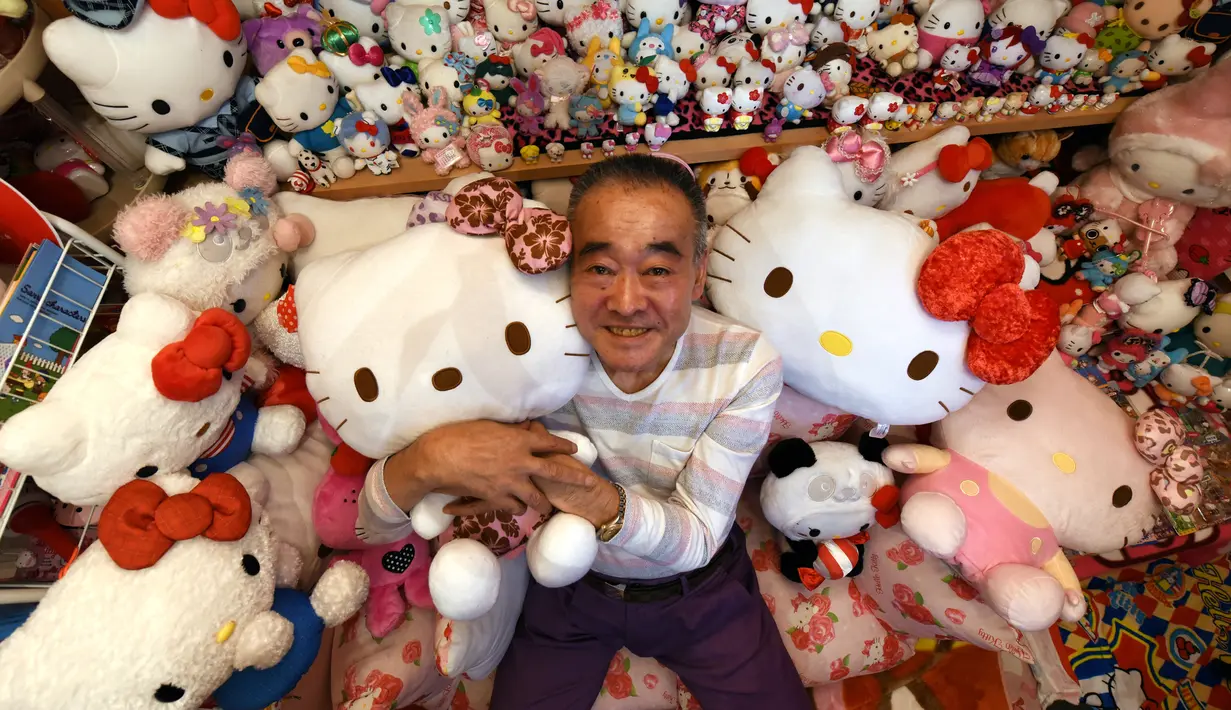 Seorang pensiunan perwira polisi Jepang yang bernama Masao Gunji berfoto bersama koleksi boneka Hello Kitty di rumahnya di Yotsukaido, Chiba, Jepang (28/6). (AFP Photo/AFPBB/Yoko Akiyoshi)