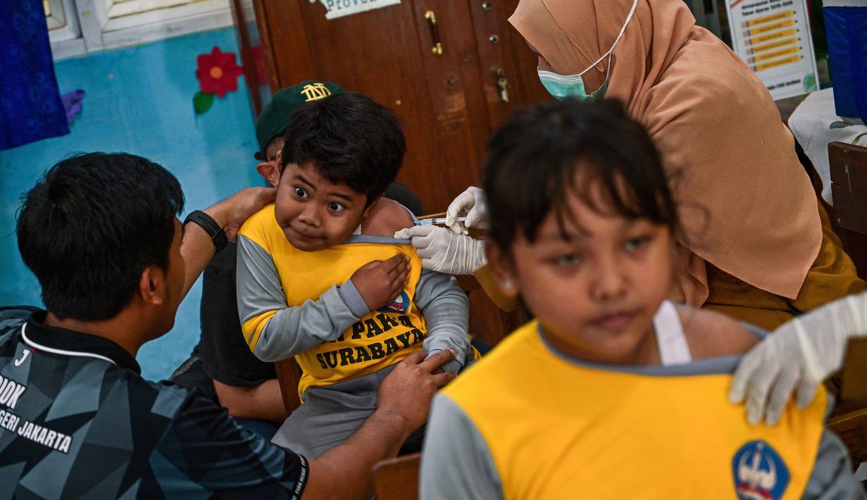 Para siswa menerima vaksin difteri di sebuah sekolah dasar di Surabaya pada Selasa 4 November 2025. Untuk diketahui, program BIAS merupakan agenda rutin untuk memastikan anak-anak terlindungi dari penyakit menular yang dapat dicegah melalui imunisasi. (Juni KRISWANTO/AFP)