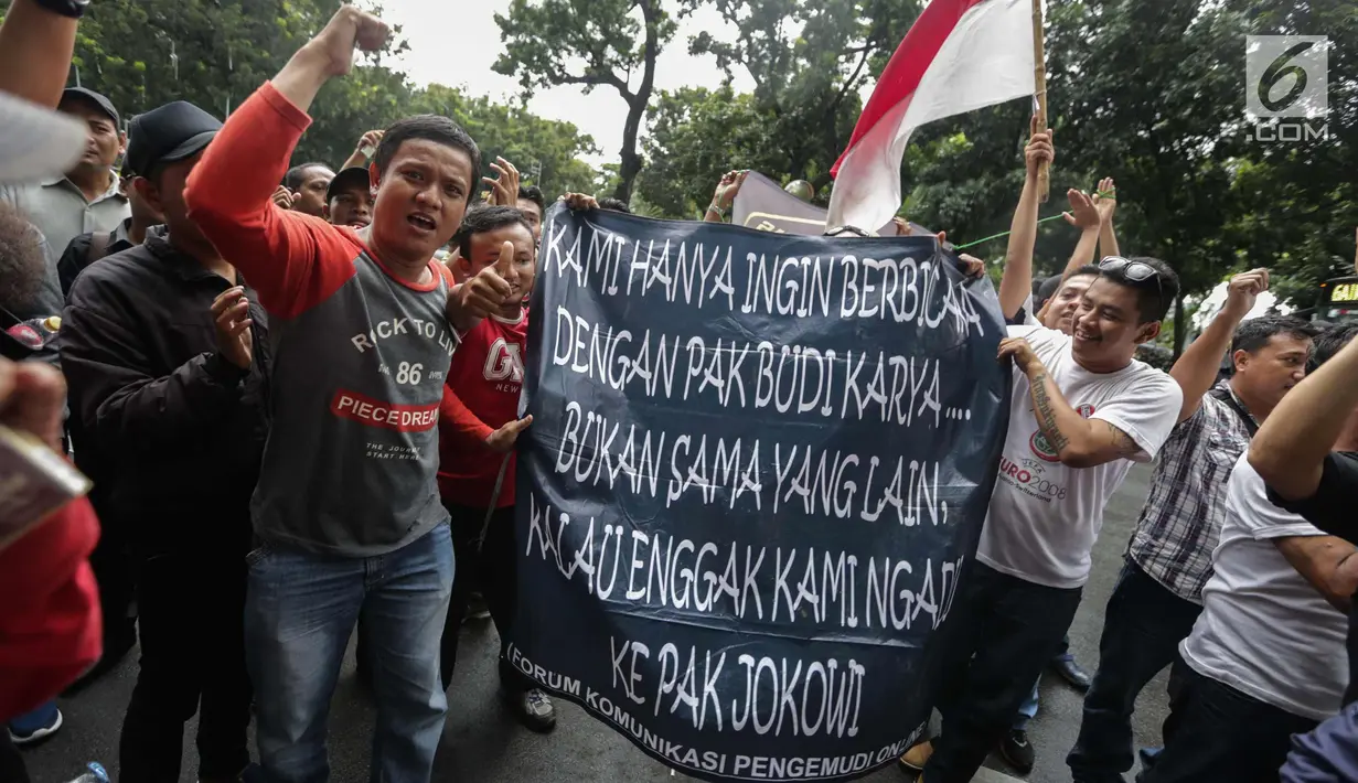 Puluhan driver online membentangkan spanduk saat unjuk rasa di depan Kemenhub, Jakarta, Senin (22/1). Dalam aksinya mereka menolak PM 108 Tahun 2017 mengenai besaran tarif yang harus sesuai dengan agrometer taksi daring.  (Liputan6.com/Faizal Fanani)