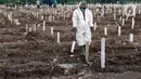Petugas pemakaman berjalan di antara makam di TPU Khusus COVID-19 Rorotan, Jakarta, Rabu (11/8/2021). Sejak awal pandemi COVID-19 Maret 2020 lalu hingga Rabu (11/8/2021), ada 112.198 orang di Indonesia meninggal dunia akibat terpapar COVID-19. (Liputan6.com/Helmi Fithriansyah)