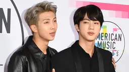 Dua personel boyband Korsel, Bangtan Boys alias BTS berpose di karpet merah ajang American Music Awards 2017 di Los Angeles, Minggu (19/11). Grup vokal dengan gaya dance keren itu merupakan grup K-pop pertama yang tampil di ajang AMA. (Mark Ralston/AFP)