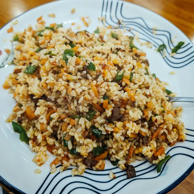 Ilustrasi nasi goreng dengan ayam goreng dari sisa nasi.