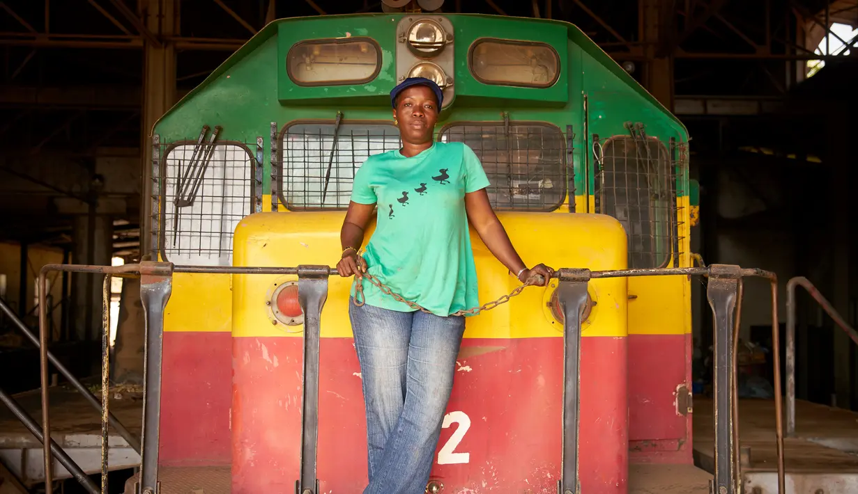 Sopir kereta Maimouna Keita (35) berpose di depan lokomotif di Bamako, Mali, Jumat (23/2). Lebih dari sembilan tahun Maimuna telah mengendarai kereta di sepanjang rute Bamako-Kayes di barat daya Mali. (AFP PHOTO/Michele CATTANI)