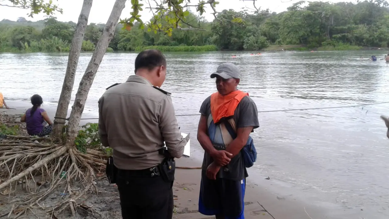Seorang petugas kepolisian tengah melakukan identifikasi korban yang hilang di muara Sungai Cibaluk, Garut