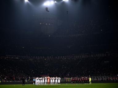 Pemain Tottenham (Kiri) dan pemain AC Milan (Kanan) bersatu untuk mengheningkan cipta untuk memperingati para korban gempa bumi yang melanda Turki dan Suriah, sebelum pertandingan babak 16 besar Liga Champions di stadion San Siro di Milan pada 15 Februari 2023. (AFP/Marco Bertorello)