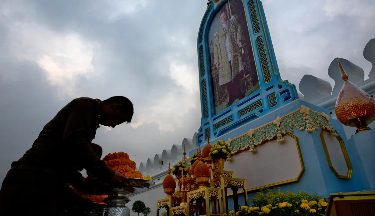 Warga Thailand memberi penghormatan di depan potret mendiang Raja Thailand Bhumibol Adulyadej di luar Grand Palace, Bangkok, Thailand (13/10). (AP Photo/Gemunu Amarasinghe)