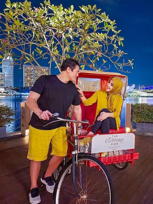 Potret keduanya saat liburan bareng di Singapura. Tampil serasi mengenakan busana senada perpaduan kuning dan hitam. Syahrini dan Reino Barack terlihat romantis dengan saling menatap. (Liputan6.com/IG/@princessyahrini)