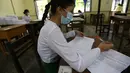 Seorang siswa yang mengenakan masker mengisi formulir informasi pribadi pada hari pendaftaran sekolah di Yangon, Myanmar (13/7/2020). Myanmar sejak Selasa (7/7) memulai pendaftaran sekolah untuk tahun ajaran 2020-2021, yang tertunda akibat pandemi COVID-19. (Xinhua/U Aung)