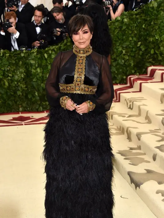 Kris Jenner berupaya untuk membetulkan jumpsuit yang digunakan Kendall Jenner saat di Met Gala. (Angela WEISS / AFP)