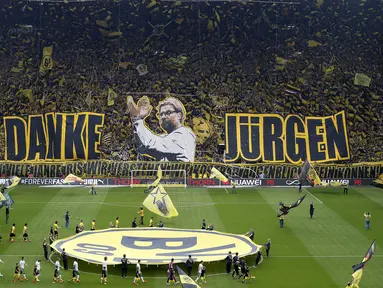 Suporter Borussia Dortmund membentangkan spanduk raksasa berwajah Juergen Klopp dan tulisan 'Danke Jurgen' (terima kasih Jurgen), sebelum laga kontra Werder Bremen di pekan terakhir Bundesliga Jerman, Sabtu (23/5) malam WIB. (AP Photo/Frank Augstein)