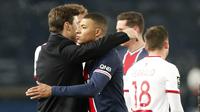 Pelatih Paris Saint-Germain (PSG), Mauricio Pochettino, memeluk Kylian Mbappe usai pertandingan melawan Brest pada laga Liga Prancis di Stadion Parc des Princes, Sabtu (9/1/2021). PSG menang dengan skor 3-0. (AP Photo/Francois Mori)