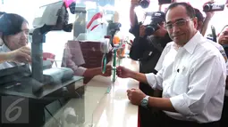 Menhub Budi Karya Sumadi membeli tiket elektronik sebelum naik KRL Commuter Line di Stasiun Juanda, Jakarta, Rabu (10/8). Menhub Budi meninjau proyek pembangunan kereta bandara Soekarno Hatta yang akan terintegrasi dari Jakarta (Liputan6.com/Angga Yuniar)