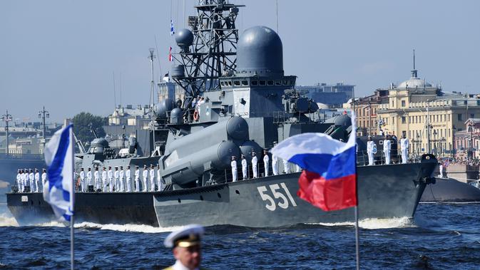 Sejumlah pelaut berjajar rapi di dek saat kapal perang Rusia berlayar selama parade Hari Angkatan Laut di Sungai Neva, Saint Petersburg, Rusia, Minggu (29/7). (Kirill Kudryavtsev/AFP)