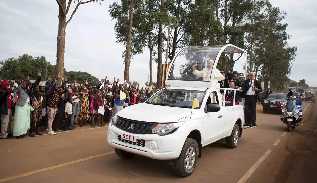 Ribuan warga Uganda berbaris dijalan memberikan sambutan yang meriah untuk Paus Francis yang ingin berceramah di kuil Uganda Martir di Namugongo, Uganda, (28/11). (REUTERS/Edward Echwalu)