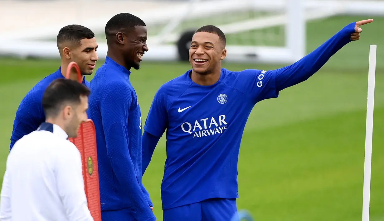 Pemain Paris Saint-Germain Nordi Mukele (tengah) tertawa bersama Kylian Mbappe saat sesi latihan di tempat latihan klub di Saint-Germain-en-Laye, Prancis, Selasa (13/9/2022). Paris Saint-Germain (PSG) akan melawan Maccabi Haifa pada pertandingan sepak bola putaran pertama Grup H Liga Champions. (FRANCK FIFE/AFP)