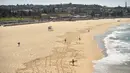 Pantai Bondi yang kosong setelah pemerintah menutup pantai paling populer di Sydney, Minggu (22/3/2020). Otoritas Australia menutup Bondi Beach  lantaran orang-orang mengabaikan larangan pemerintah untuk tidak berkumpul dalam jumlah besar guna menekan penyebaran virus corona. (PETER PARKS/AFP)