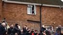 Seorang warga menonton dari jendela pada laga Piala FA 2024/2025 antara Tamworth melawan Tottenham Hotspur di The Lamb Ground, Tamworth, Inggris, Minggu (12/01/2025) waktu setempat. (AFP/Henry Nicholls)