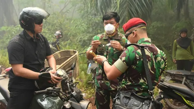 Panglima TNI Marsekal Hadi Tjahjanto bersiap memasuki lahan terbakar di Bengkalis.