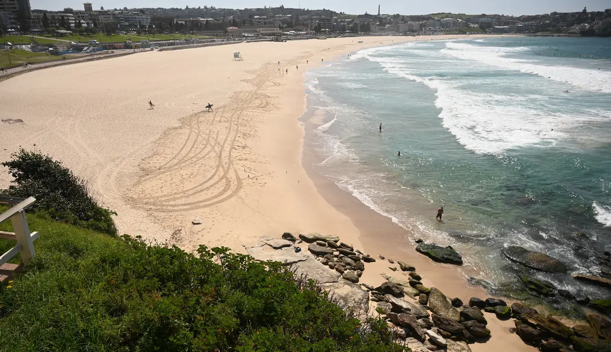 Pantai Bondi yang kosong setelah pemerintah menutup pantai paling populer di Sydney, Minggu (22/3/2020). Otoritas Australia menutup Bondi Beach  lantaran orang-orang mengabaikan larangan pemerintah untuk tidak berkumpul dalam jumlah besar guna menekan penyebaran virus corona. (PETER PARKS/AFP)